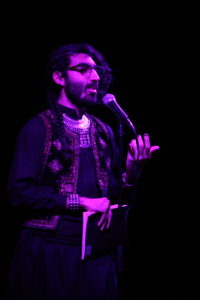 photo of levon kafafian, standing speaking into a microphone on a stage